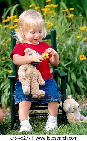 Little girl sitting in chair with her teddy bear View Large Photo Image Stock Image - Little girl sitting in chair with her teddy bear. Fotosearch