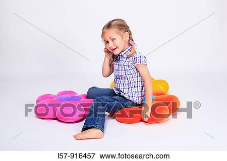 little girl sitting on cushion with mobile phone, Switzerland View Large Photo Image Stock Photo - little girl sitting on cushion with mobile phone, Switzerland. Fotosearch
