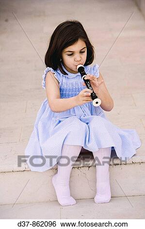 Little girl sitting on the floor and playing the flute View Large Photo Image Stock Photograph - Little girl sitting on the floor and playing the flute. Fotosearch