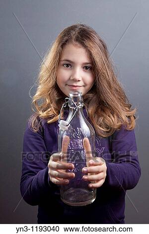 Little girl smiling and holding an empty bottle. View Large Photo Image Stock Image - Little girl smiling and holding an empty bottle.. Fotosearch
