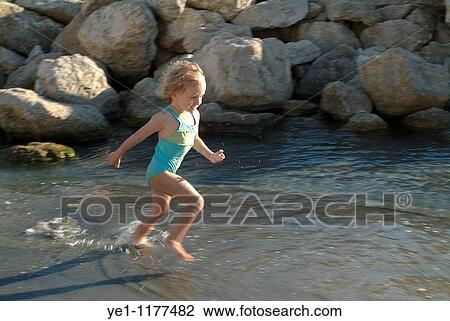 Little girl splashing in a tidal pool at the beach, Prophete, Marseille, France. View Large Photo Image Stock Image - Little girl splashing in a tidal pool at the beach, Prophete, Marseille, France.. Fotosearch