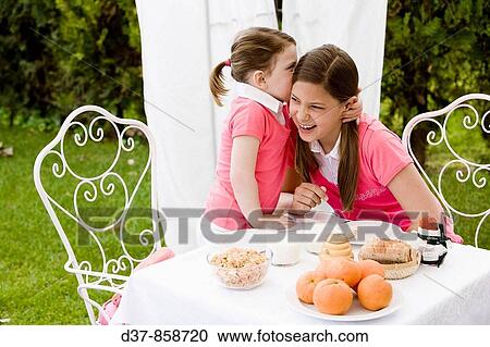Little girl whispering a secret to her sister View Large Photo Image Stock Image - Little girl whispering a secret to her sister. Fotosearch