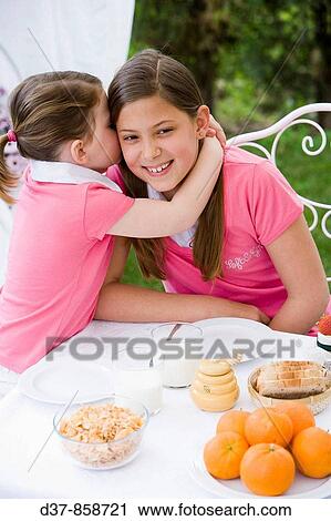 Little girl whispering a secret to her sister View Large Photo Image Stock Image - Little girl whispering a secret to her sister. Fotosearch