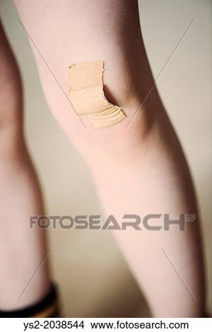 Little girl with bandaid covering wounded knee. View Large Photo Image Picture - Little girl with bandaid covering wounded knee.. Fotosearch