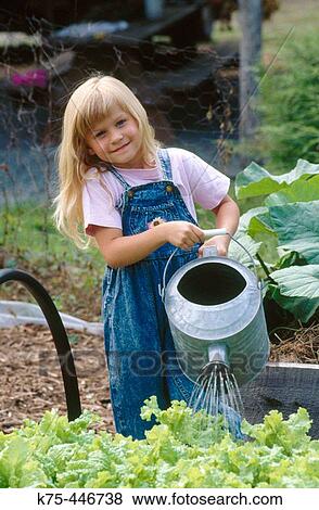 Little girl with big watering can in garden View Large Photo Image Stock Photo - Little girl with big watering can in garden. Fotosearch