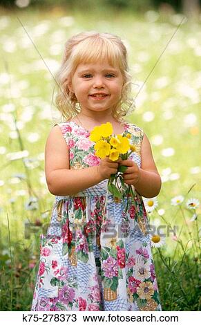 Stock Image - Little girl with bouquet of flowers. Fotosearch