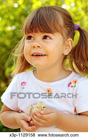 Stock Photo - Little girl with chick. Fotosearch