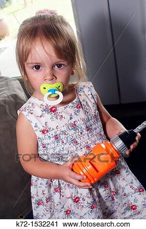 Little girl with pacifier holds a toy drill View Large Photo Image Stock Image - Little girl with pacifier holds a toy drill. Fotosearch