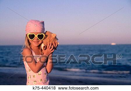 Little girl with seashell View Large Photo Image Stock Photo - Little girl with seashell. Fotosearch