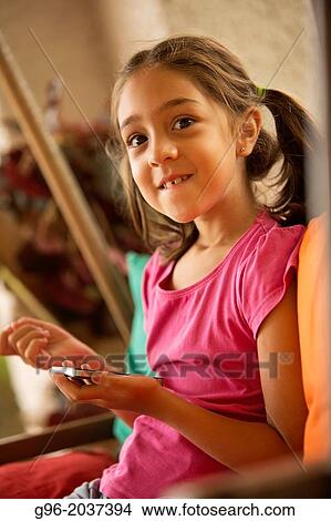 Picture - Little girl with smart phone.. Fotosearch