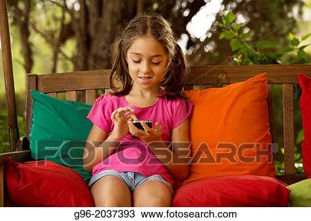 Stock Image - Little girl with smart phone.. Fotosearch