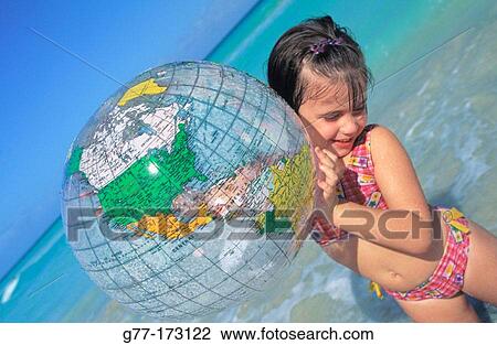 Little girl with world globe on the beach View Large Photo Image Stock Image - Little girl with world globe on the beach. Fotosearch