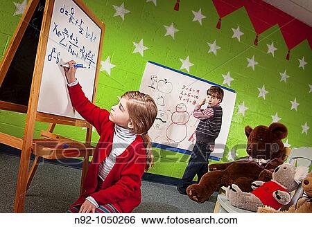 Little girl writing amazing math problem on board while boy looks on in amazement View Large Photo Image Stock Photograph - Little girl writing amazing math problem on board while boy looks on in amazement. Fotosearch