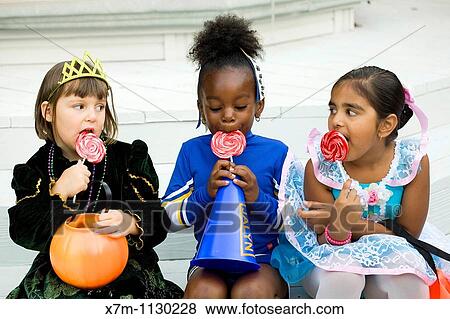 Little girls dressed in Halloween costumes enjoy their lollipops View Large Photo Image Stock Photo - Little girls dressed in Halloween costumes enjoy their lollipops. Fotosearch