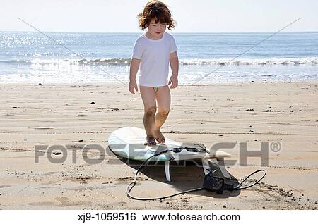 Little surfer waiting for the waves View Large Photo Image Stock Photograph - Little surfer waiting for the waves. Fotosearch