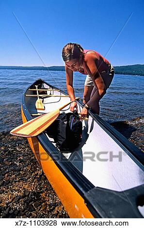 Stock Photo - Liz Anderson, canoe tripping and stowing some gear at Ponderosa State Park on Payette Lake near the city of McCall in central idaho. Fotosearch