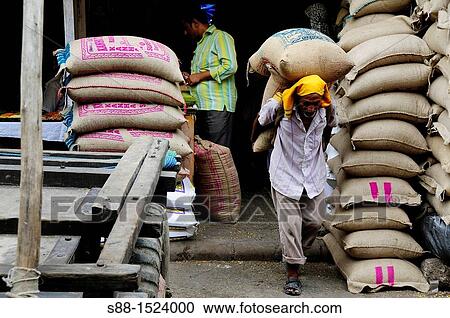 Stock Image - Loading sacks of grain at Chandni Chowk, Old Delhi. Fotosearch