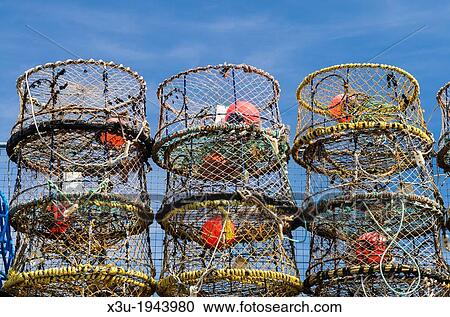 Stock Image - Lobster pots stacked on the quay in the fishing town of Brixham, Devon, England.. Fotosearch