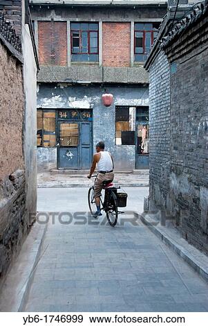local chinese man on a biking in the streets of Pingyao, Shaanxi Province, China. View Large Photo Image Stock Photo - local chinese man on a biking in the streets of Pingyao, Shaanxi Province, China.. Fotosearch