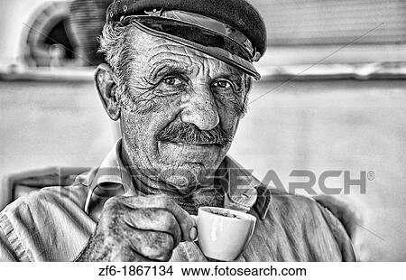 Local man portrait with Greek coffee with Greek hat at restuarant in white in Mykonos in Greek Islands in Greece Europe View Large Photo Image Picture - Local man portrait with Greek coffee with Greek hat at restuarant in white in Mykonos in Greek Islands in Greece Europe. Fotosearch