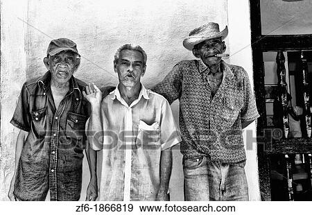 Local old men with cigar against bright yellow wall of building of the old colonial city of Trinidad in Cuba View Large Photo Image Stock Photo - Local old men with cigar against bright yellow wall of building of the old colonial city of Trinidad in Cuba. Fotosearch