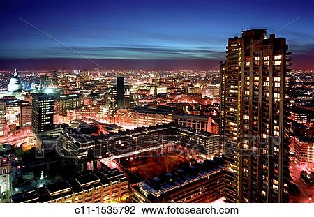 Stock Image - london skyline at night shot from barbican looking towards city westminster london eye river thames st pauls england uk. Fotosearch