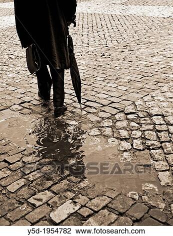 lonely man in long coat walking with umbrella and briefcase, sidewalk, paving stones, after rain, sepia, old fashioned, actually Madrid, Spain, Europeans View Large Photo Image Stock Image - lonely man in long coat walking with umbrella and briefcase, sidewalk, paving stones, after rain, sepia, old fashioned, actually Madrid, Spain, Europeans. Fotosearch
