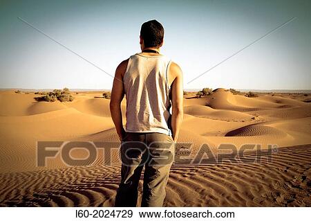 Stock Photo - Lonely man in M? Hamid desert, Morocco.. Fotosearch