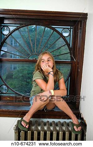 Long blond haired preteen girl sitting on a radiator by a window in her house, thinking. View Large Photo Image Stock Image - Long blond haired preteen girl sitting on a radiator by a window in her house, thinking.. Fotosearch