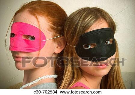 Long red-hair and blond-hair teen girls, both wearing masks over their eyes, posing together View Large Photo Image Picture - Long red-hair and blond-hair teen girls, both wearing masks over their eyes, posing together. Fotosearch