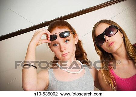 Long red-hair and blond-hair teen girls, both wearing sunglasses, clowning around together View Large Photo Image Stock Image - Long red-hair and blond-hair teen girls, both wearing sunglasses, clowning around together. Fotosearch