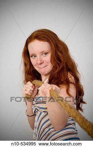 Long red-hair teen girl pulling on a rope View Large Photo Image Stock Photography - Long red-hair teen girl pulling on a rope. Fotosearch