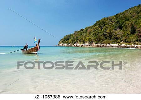 Stock Photograph - Long tailed boat at Karon Noi beach Phuket, Thailand. Fotosearch