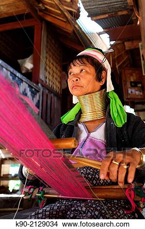 Longneck Karen woman sitting on the floor and weaving a pink scarf, Mae Hong Son, Thailand, Southeast Asia. View Large Photo Image Picture - Longneck Karen woman sitting on the floor and weaving a pink scarf, Mae Hong Son, Thailand, Southeast Asia.. Fotosearch