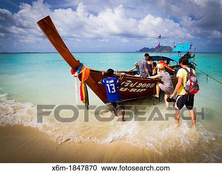 Stock Image - Longtail boat and tourists on Long beach Phi Phi Don island Krabi province, Andaman Sea, Thailand. Fotosearch