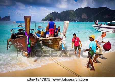 Stock Photography - Longtail boat and tourists on Long beach Phi Phi Don island Krabi province, Andaman Sea, Thailand. Fotosearch
