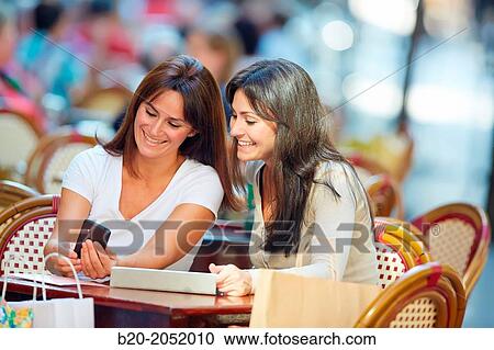 Looking a smartphone. Women sisters 35 and 40 years taking coffee on a terrace. Donostia. San Sebastian. Gipuzkoa. Basque Country- Spain. View Large Photo Image Stock Image - Looking a smartphone. Women sisters 35 and 40 years taking coffee on a terrace. Donostia. San Sebastian. Gipuzkoa. Basque Country- Spain.. Fotosearch