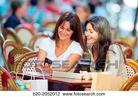 Looking a smartphone. Women sisters 35 and 40 years taking coffee on a terrace. Donostia. San Sebastian. Gipuzkoa. Basque Country- Spain. View Large Photo Image Stock Image - Looking a smartphone. Women sisters 35 and 40 years taking coffee on a terrace. Donostia. San Sebastian. Gipuzkoa. Basque Country- Spain.. Fotosearch