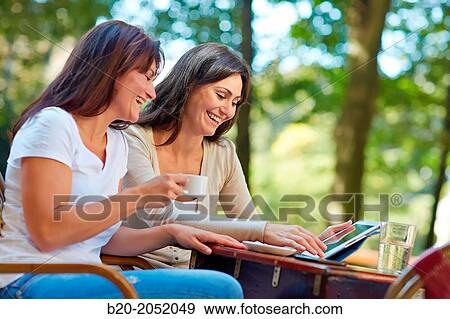Looking a tablet. Women sisters 35 and 40 years taking coffee on a terrace. Donostia. San Sebastian. Gipuzkoa. Basque Country- Spain. View Large Photo Image Stock Photo - Looking a tablet. Women sisters 35 and 40 years taking coffee on a terrace. Donostia. San Sebastian. Gipuzkoa. Basque Country- Spain.. Fotosearch