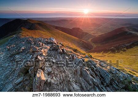 Stock Image - Looking down Hope Gill from the summit of Hopegill Head at sunset in the Lake District. Whiteside to the left and Ladyside right.. Fotosearch