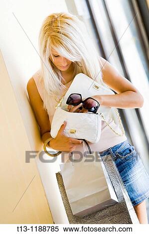 Looking for something in her purse young woman View Large Photo Image Stock Photography - Looking for something in her purse young woman. Fotosearch