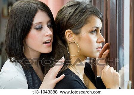 Looking over her shoulder, two girlfriends behind a window View Large Photo Image Stock Photo - Looking over her shoulder, two girlfriends behind a window. Fotosearch