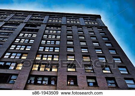 Stock Photo - Looking Up at an Office Building, Late in the Day, Some Light Aglow.. Fotosearch