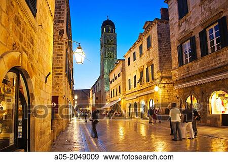 Stock Photo - Looking West down the Stradun square towards pile gate and the Franciscan bell tower at night with shiny marble street surface, old town Dubrovnik. Croatia. Fotosearch