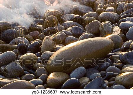 Los primeros rayos del sol centelleando entre las piedras en la costa de Mioo, Castro Urdiales, Cantabria View Large Photo Image Stock Photo - Los primeros rayos del sol centelleando entre las piedras en la costa de Mioo, Castro Urdiales, Cantabria. Fotosearch
