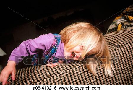 Lost in playtime, a happy three year old little girl frolics on her parents sofa. View Large Photo Image Stock Photograph - Lost in playtime, a happy three year old little girl frolics on her parents sofa.. Fotosearch