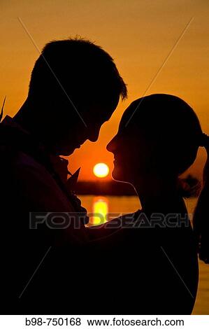 Lovers in silhouette at sunset View Large Photo Image Stock Photo - Lovers in silhouette at sunset. Fotosearch