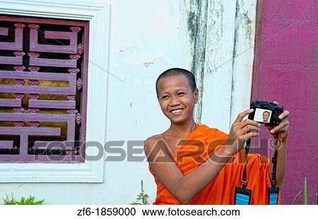 Luang Phabang Laos Lao young monk relaxing laughing with camera self portrait in garden Asia Asian View Large Photo Image Stock Image - Luang Phabang Laos Lao young monk relaxing laughing with camera self portrait in garden Asia Asian. Fotosearch