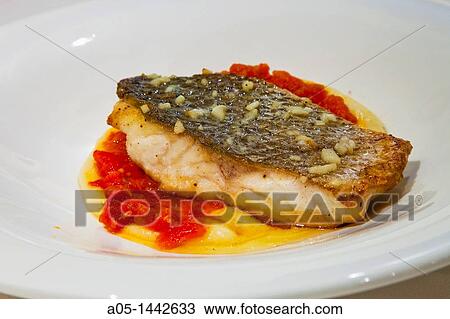 Stock Image - Lubina fish with patatoes and tomato jam at El Tunel restaurant, Lloret de Mar, La Selva, Costa Brava, Girona province, Catalonia, Spain.. Fotosearch