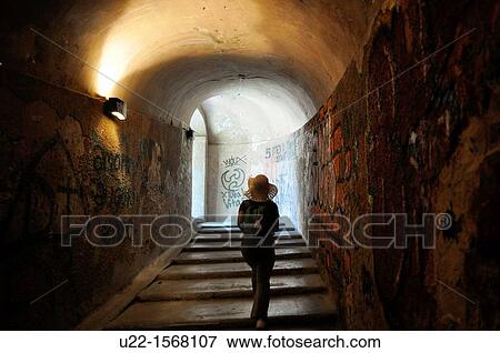 Stock Photo - Lucca (Italy): a tourist walking through a tunnel of the ancient walls that surround the city center. Fotosearch